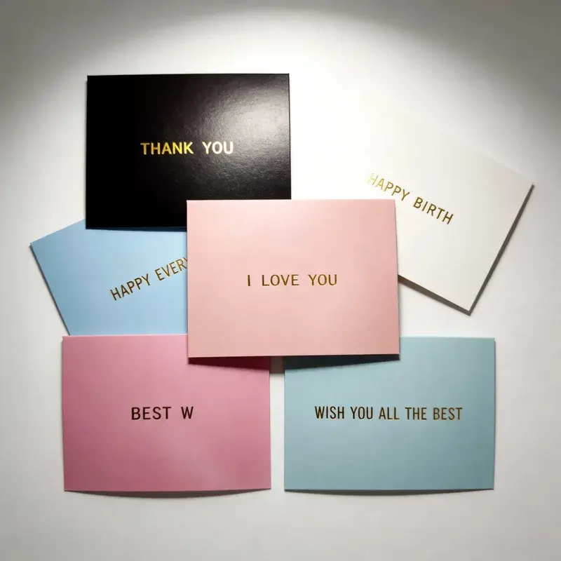 Cards in soft colors with short gold-colored printed messages.