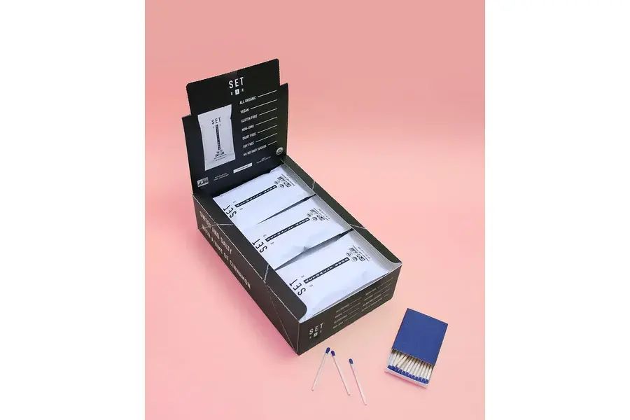 Open black presentation box holding white stationery items.