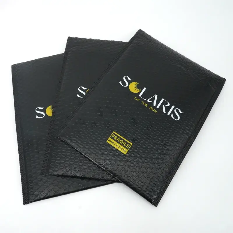 Overlapping black bubble mailers with gold and white lettering.