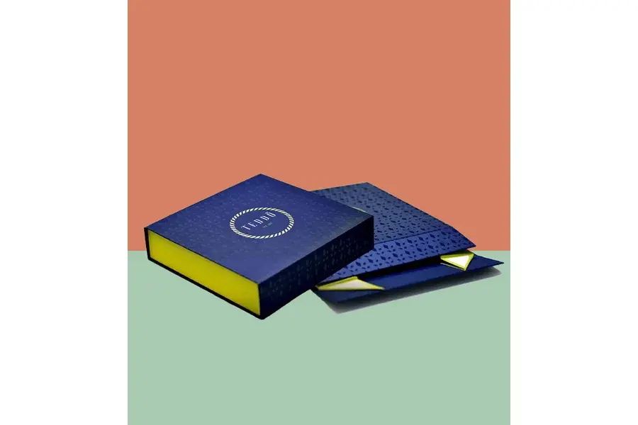 Blue and yellow gift box with its lid and flat panels beside it.