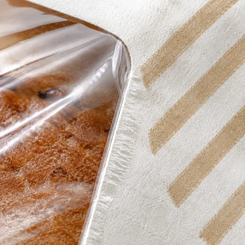 Close view of bread through a paper bag's clear window.