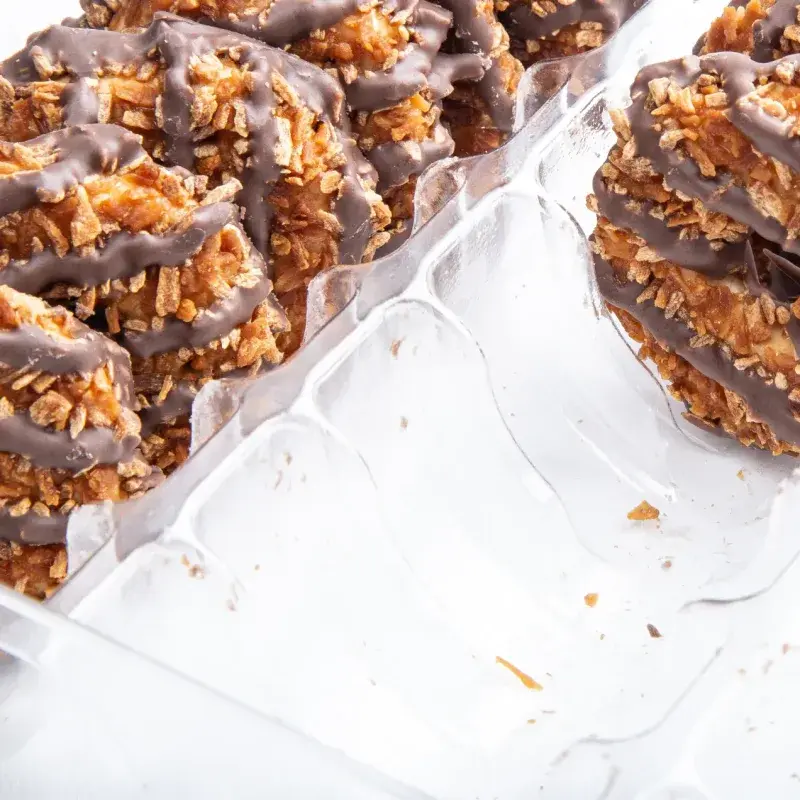 Chocolate-coated snacks displayed in clear individual containers.