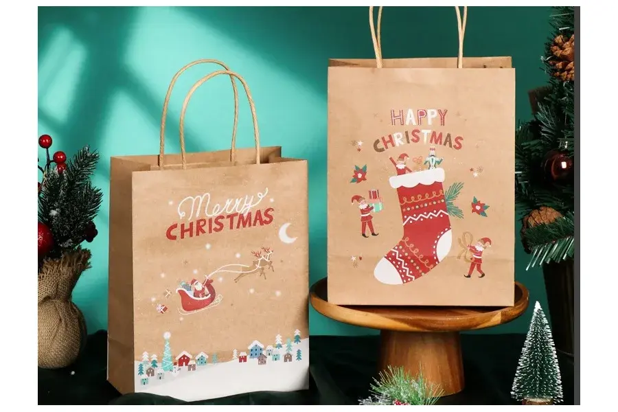 Two Christmas-printed kraft bags with twisted paper handles.