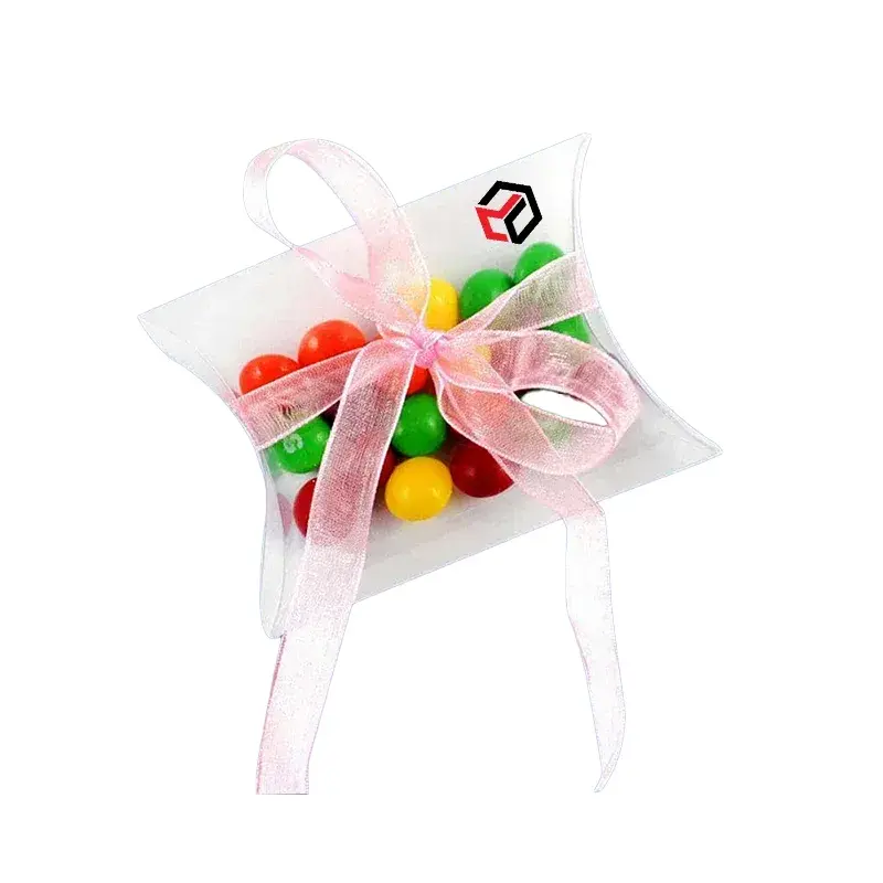 Clear favor box filled with sweets and tied with pink ribbon.