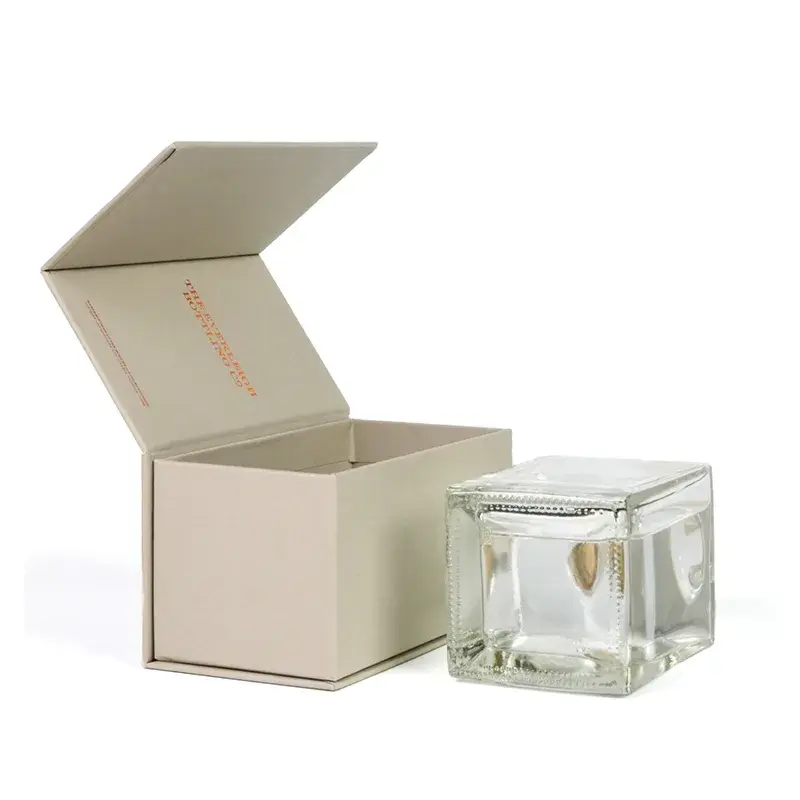 Open cream box beside a square glass jar.