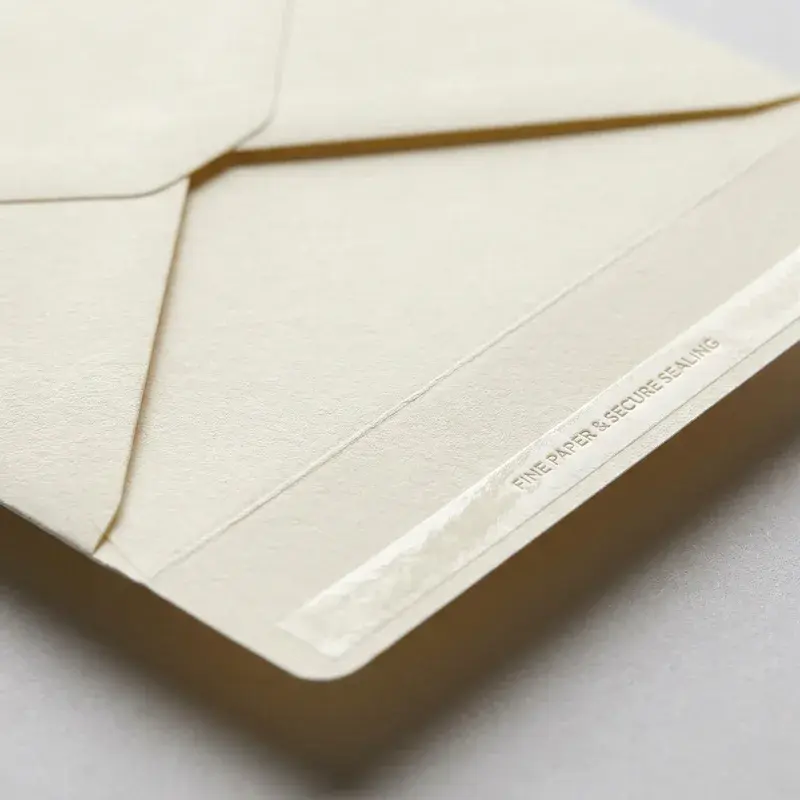 Close view of a cream envelope flap and textured paper edge.