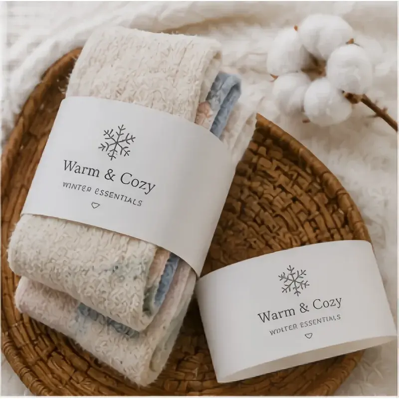 Folded cream textiles wrapped in a white printed paper sleeve.