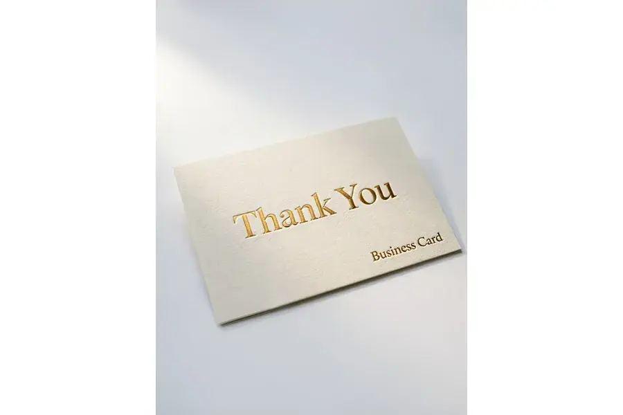 Angled cream card with gold-colored thank-you lettering.