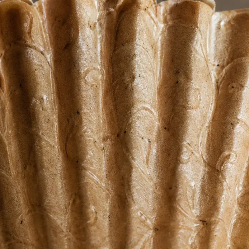 Close view of brown paper with long folds and wrinkles.