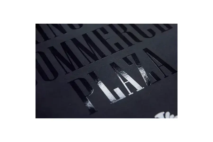 Glossy black lettering catching light on a dark paper surface.