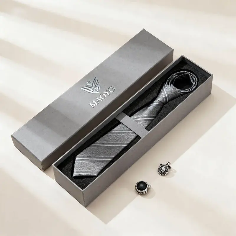 Open gray gift box holding a tie and matching accessories.