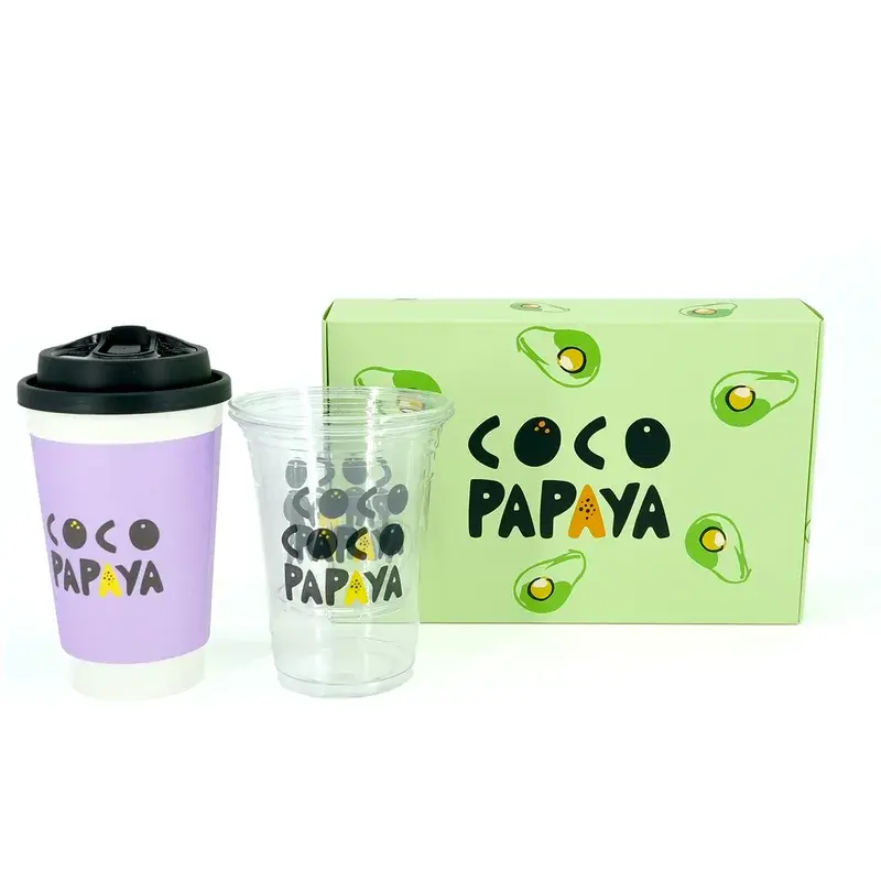 Green printed box beside a clear cup and a lidded takeaway cup.