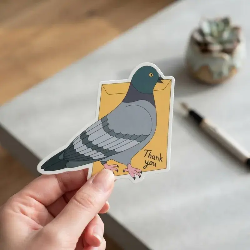 Hand holding an illustrated pigeon-shaped thank-you card.