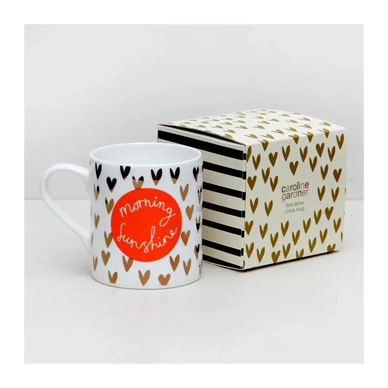Heart-patterned mug beside a matching striped gift box.