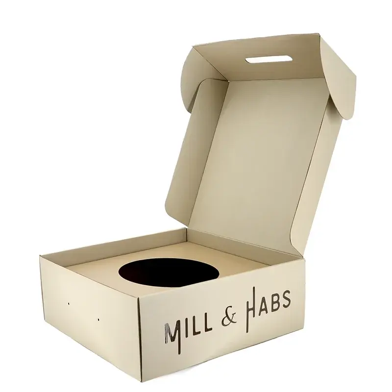 Open kraft box with a circular insert and dark printed lettering.