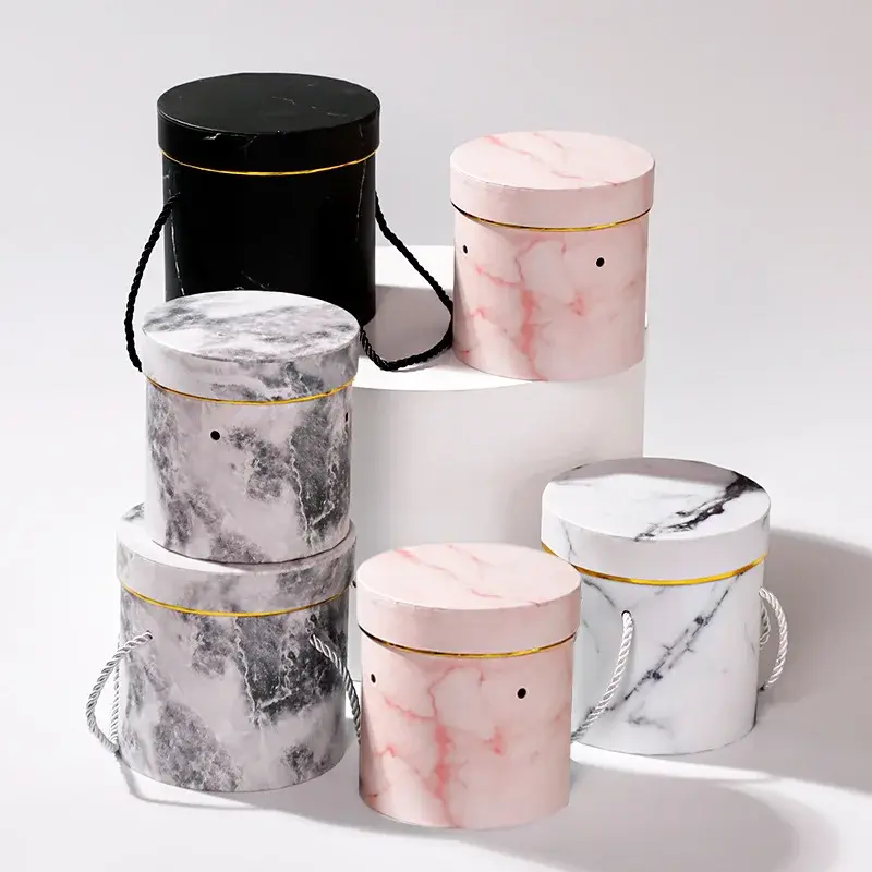 Round boxes with marble patterns beside pink and black tubes.