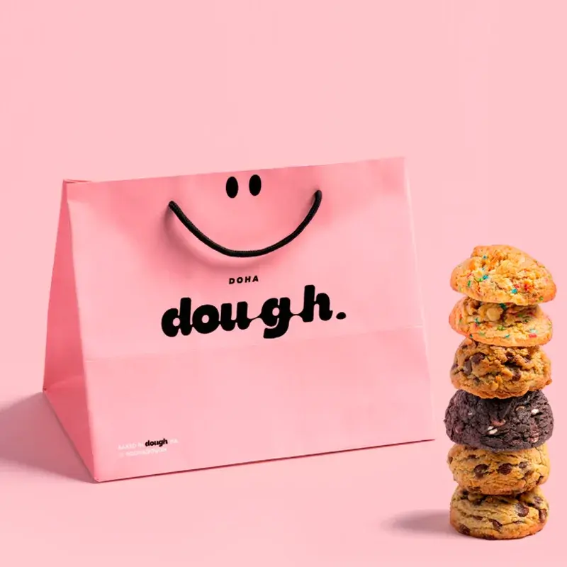 Pink shopping bag beside a tall stack of cookies.