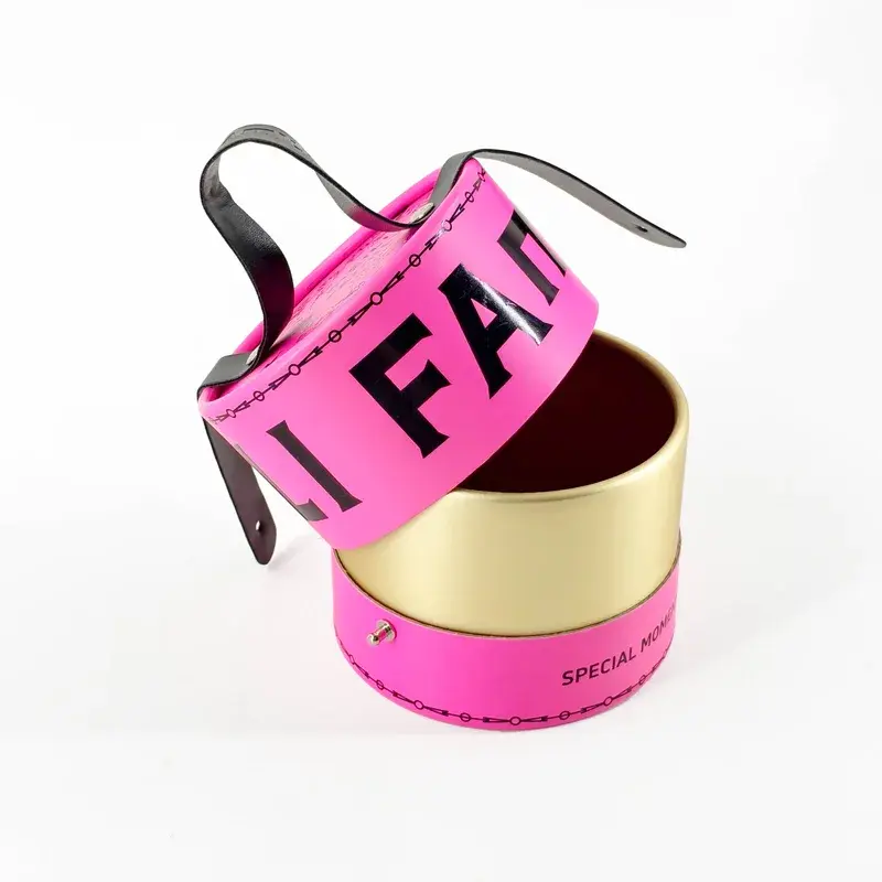 Pink cylindrical box with black handles and its lid raised.