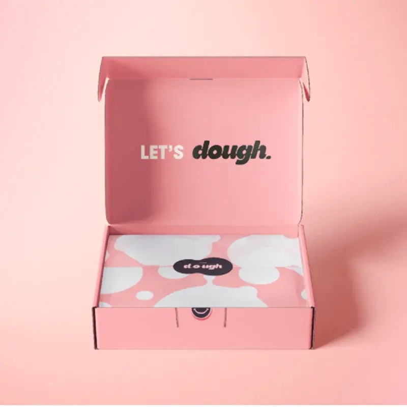 Open pink cookie mailer containing pink printed wrapping paper.