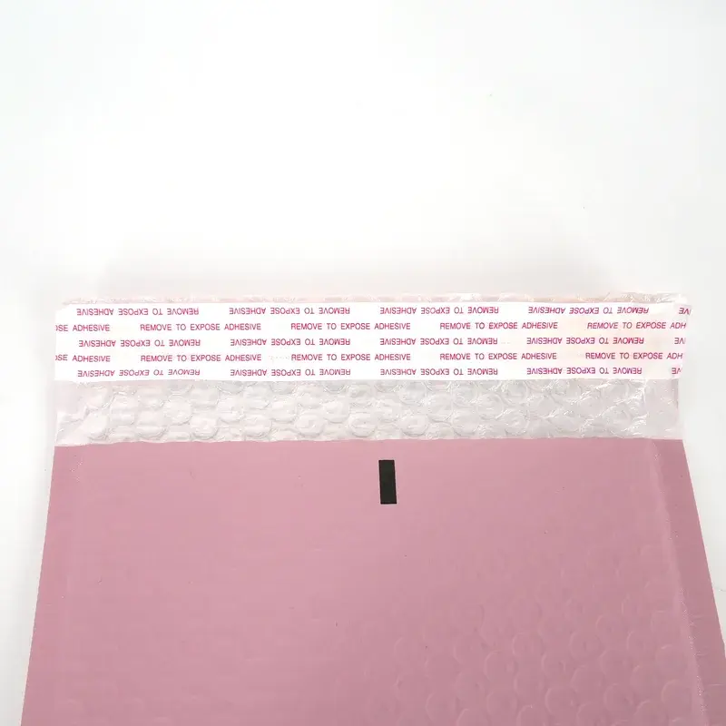 Close view of a pink mailer and its printed adhesive liner.