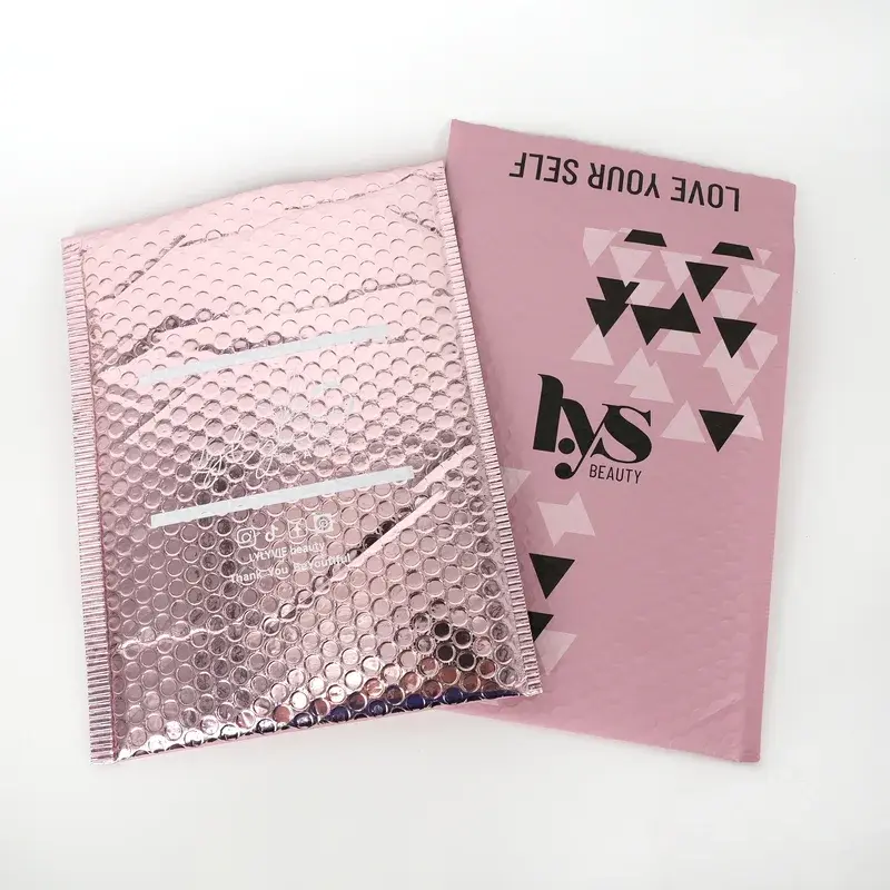 Pink bubble mailers with dark geometric printing.
