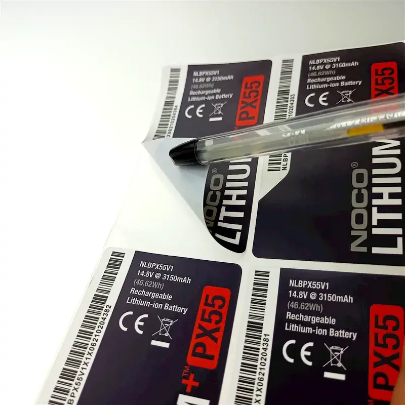 Printed black and purple label sheet viewed from an angle.