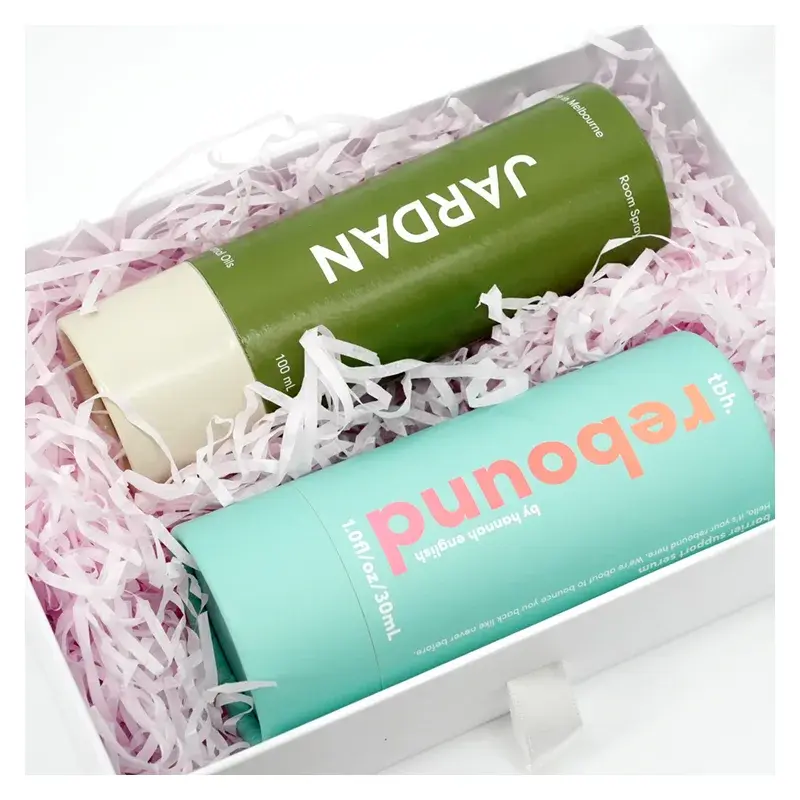 Green and turquoise printed tubes nestled in shredded paper.