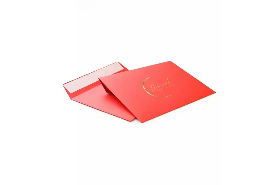 Red mailing envelopes with open flaps and small gold-colored printing.