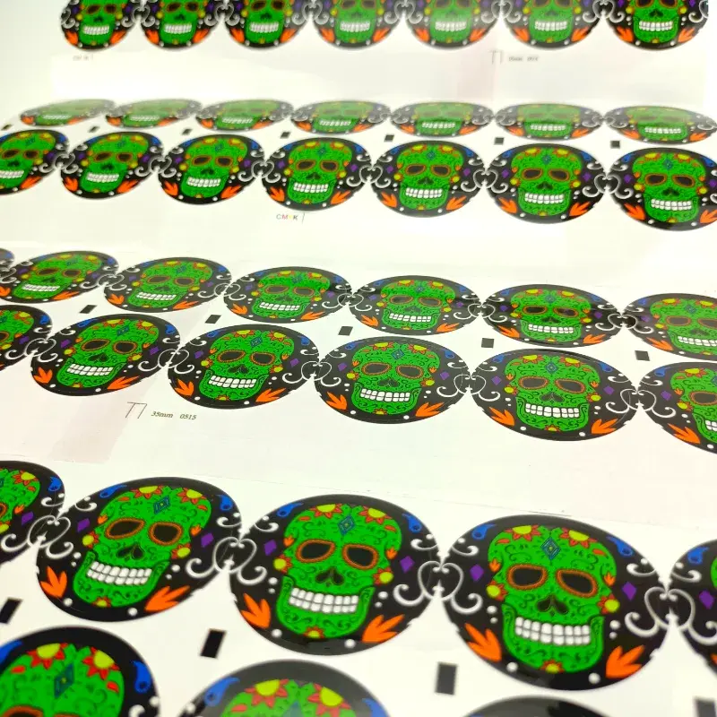 Rows of round green printed stickers on white backing sheets.