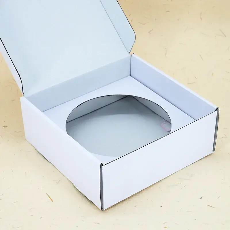 Angled view of a white box with a circular insert opening.