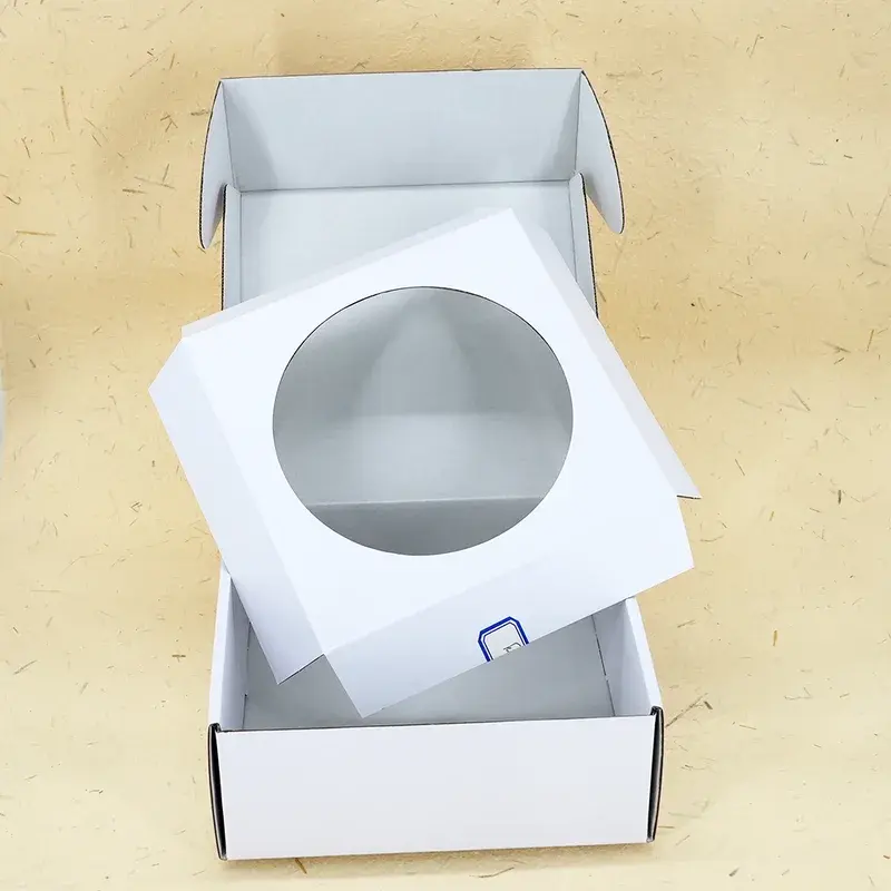 Open white box with its circular-cutout insert lifted upward.