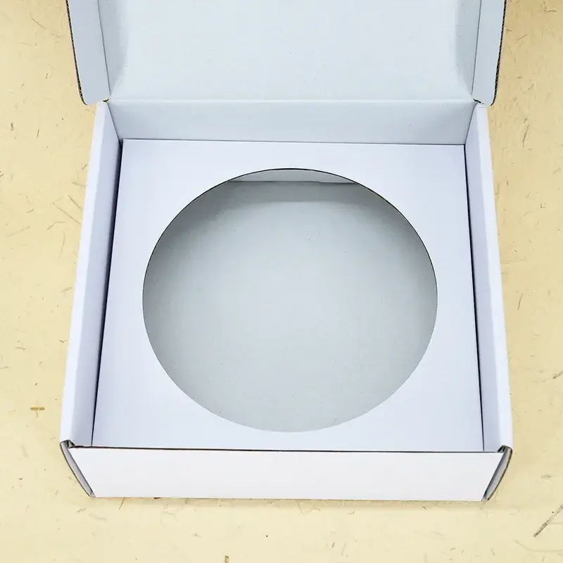 Open white box viewed from above with a circular insert cutout.