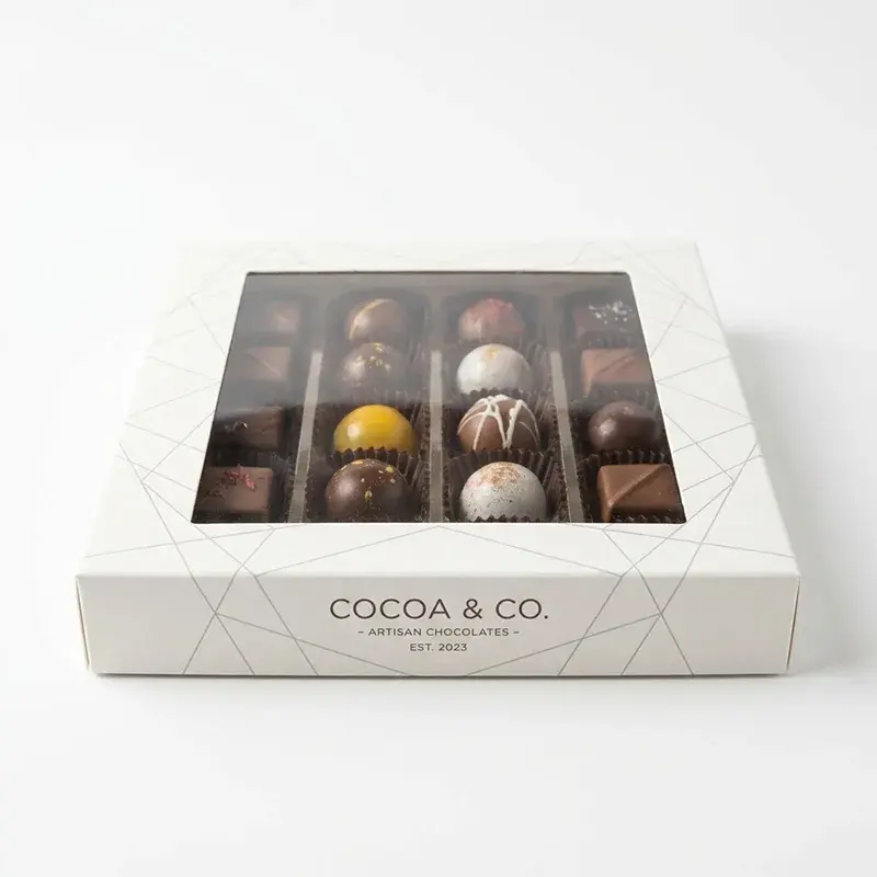 White chocolate box with a window above a divided chocolate tray.