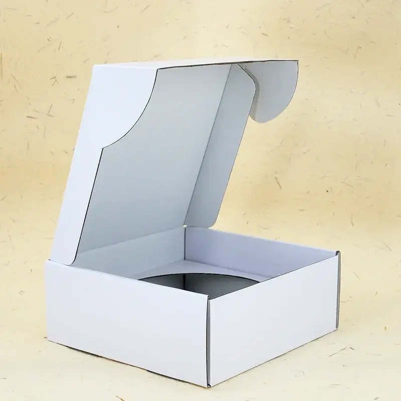 Open white box viewed from the side with its lid raised.