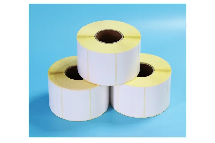 Three white blank label rolls stacked on a blue background.