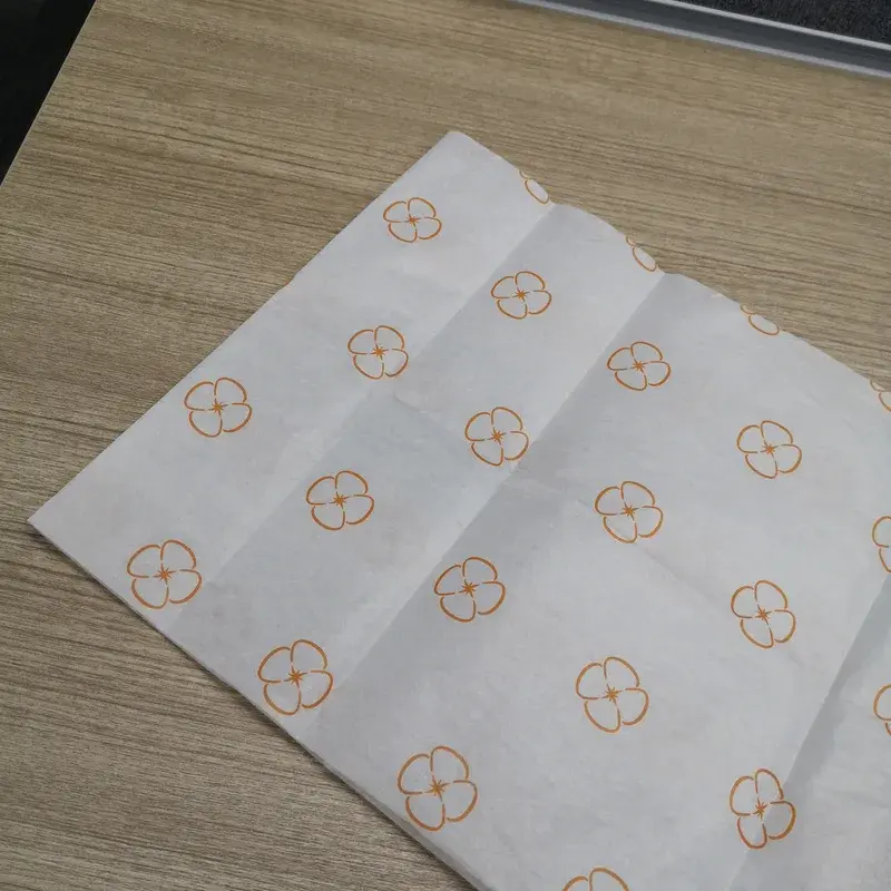 White tissue sheet with repeating small gold-colored emblems.