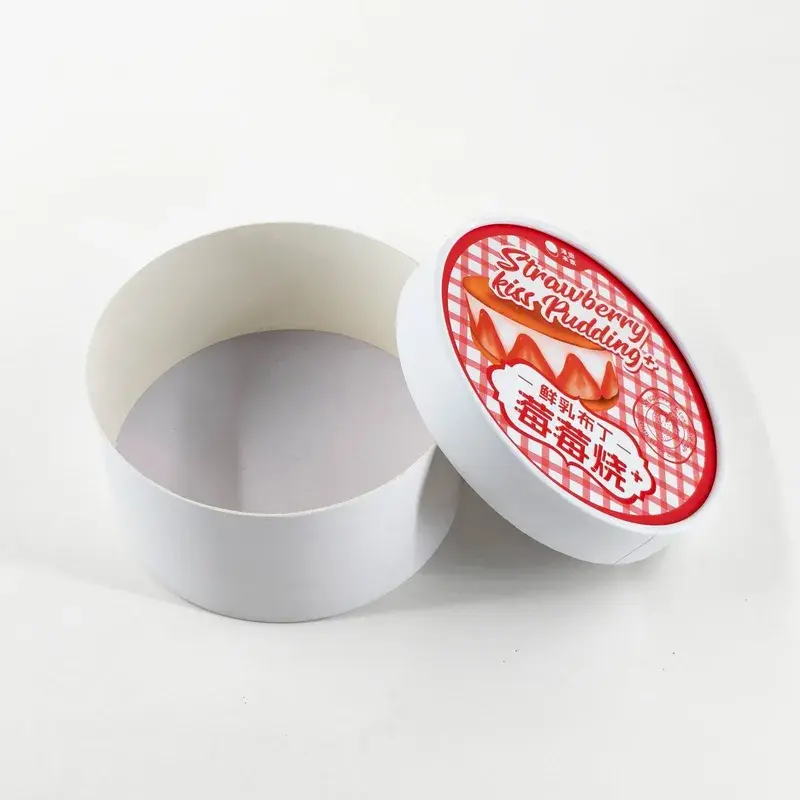 Open white round box beside a red and white printed lid.