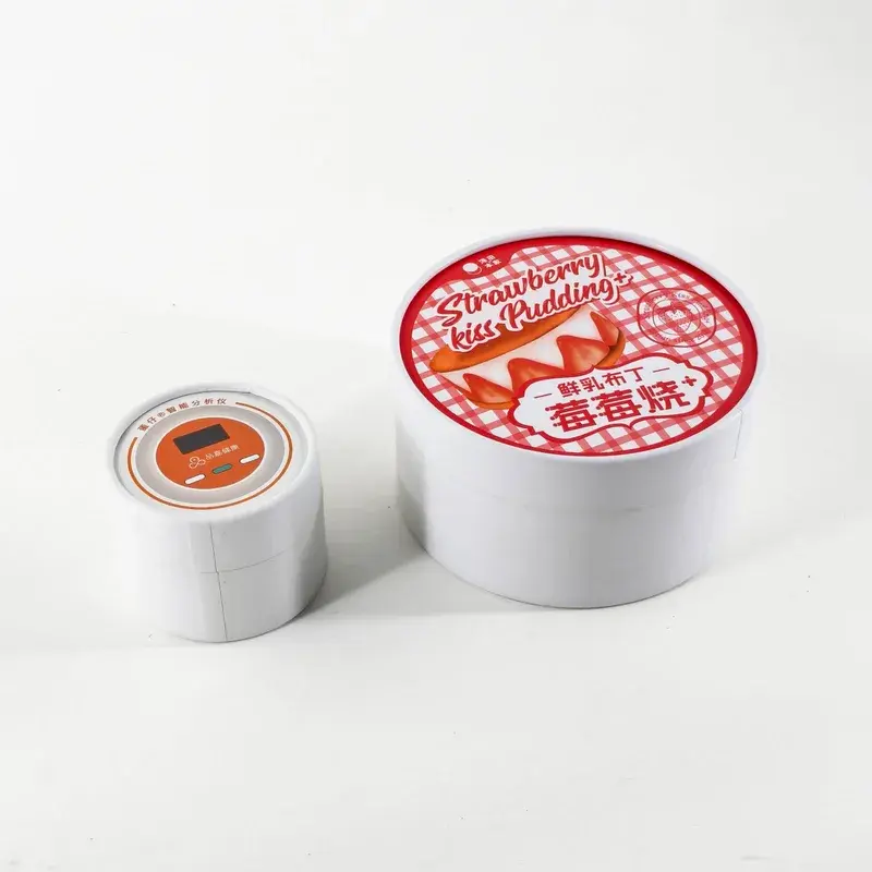 Two white round containers with different printed lids.