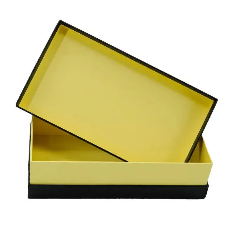 Open yellow presentation box with black edges and a loose lid.